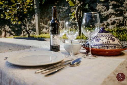 a table with a bottle of wine and two glasses at Casa da Adega - Quinta da Portela in Terras de Bouro