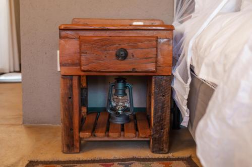 a nightstand with a lantern on it next to a bed at Umkumbe Bush Lodge - Luxury Tented Camp in Sabi Sand Game Reserve