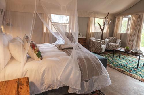 a bedroom with a bed with a mosquito net at Umkumbe Bush Lodge - Luxury Tented Camp in Sabi Sand Game Reserve