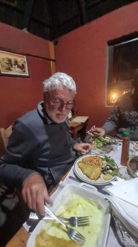 a man sitting at a table with a plate of food at Authentic Bicycle Tours and Backpackers in Soweto