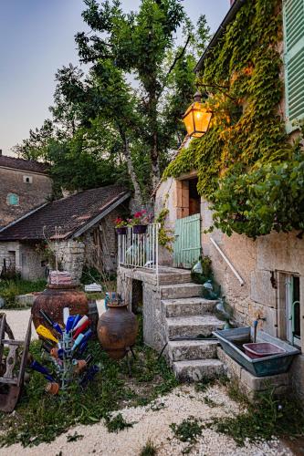a stone house with stairs and a sink in front of it at Le Domaine des Carriers in Chevroches