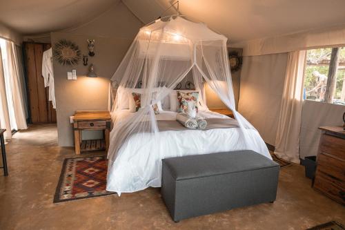 a bedroom with a bed with a canopy at Umkumbe Bush Lodge - Luxury Tented Camp in Sabi Sand Game Reserve