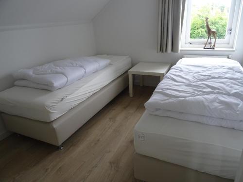 2 camas en una habitación con ventana en Kustverhuur, Vakantiepark Fort Soleil 14, en Breskens