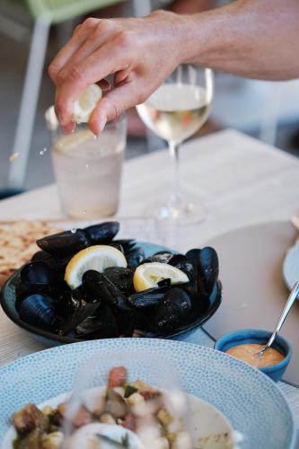 a person is putting food in a plate of food at El Vicenç de la Mar - Adults Only - Over 12 in Pollença
