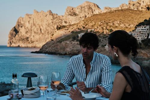 a man and a woman sitting at a table with wine glasses at El Vicenç de la Mar - Adults Only - Over 12 in Pollença