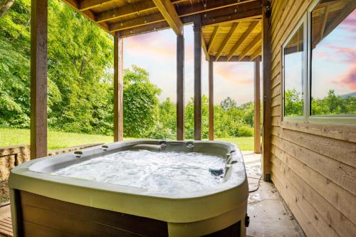 a jacuzzi tub in a house with windows at --Mountain Chalet Getaway with Breathtaking View Next to Tail of Dragon-- in Robbinsville