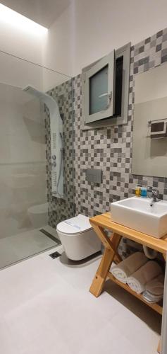 a bathroom with a sink and a shower and a toilet at Irina Beach Hotel in Tigaki