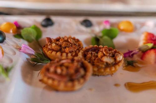 a plate with three pastries with nuts on top at Umkumbe Bush Lodge - Luxury Tented Camp in Sabi Sand Game Reserve