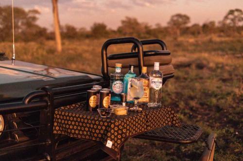 a table with bottles of alcohol on the back of a truck at Umkumbe Bush Lodge - Luxury Tented Camp in Sabi Sand Game Reserve