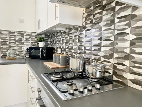 a kitchen with a stove with pots and pans on it at 89 St John's Road Terrace House in Newcastle upon Tyne