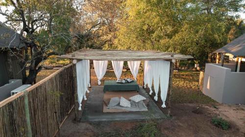 a gazebo with a table and chairs in a yard at Umkumbe Bush Lodge - Luxury Tented Camp in Sabi Sand Game Reserve