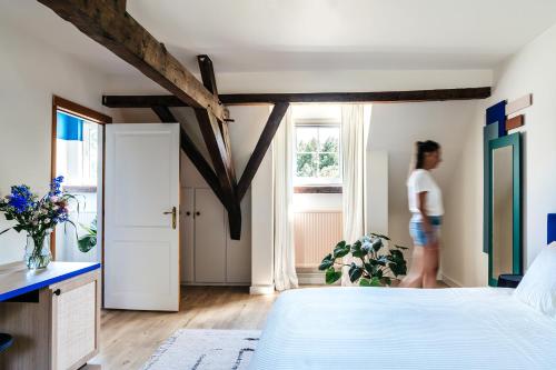 Villa Parkbos في De Pinte: امرأة تقف في غرفة نوم مع سرير