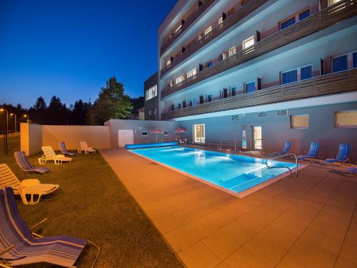 une grande piscine en face d'un bâtiment dans l'établissement EA Hotel Kraskov, à Starý Dvŭr