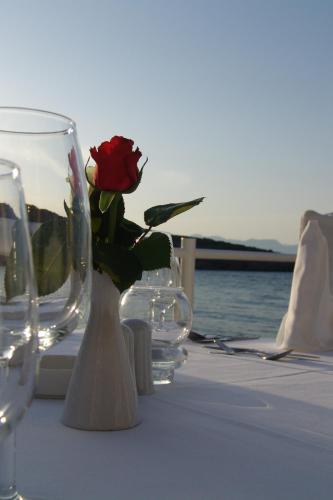 a vase with a rose in it sitting on a table at Istron Bay Hotel in Istron