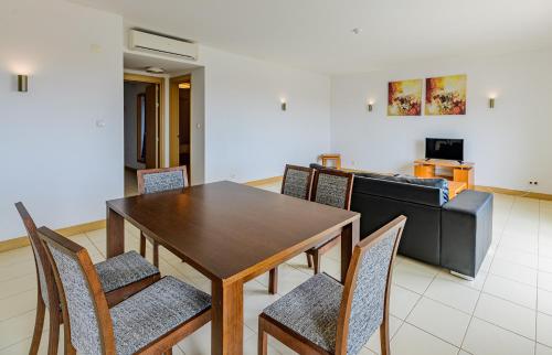 a dining room with a table and chairs and a couch at Agua Hotels Sal Vila Verde in Santa Maria