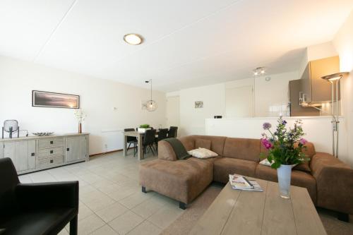 a living room with a couch and a table at Horsetellerie Rheezerveen in Hardenberg