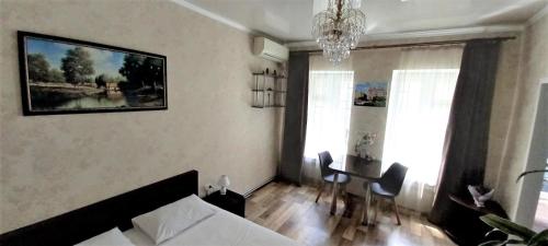 a living room with a couch and a table and a chandelier at Apartments Ilona in Odesa