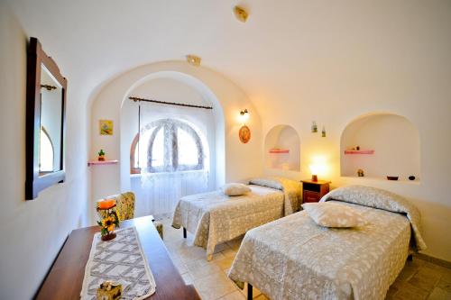 sypialnia z 2 łóżkami i stołem w obiekcie I Trulli di Alejandro w mieście Locorotondo