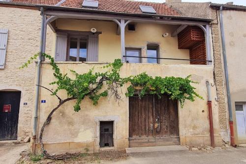 een oud huis met een grote houten deur bij Maison de charme - Au coeur de Puligny-Montrachet in Puligny-Montrachet