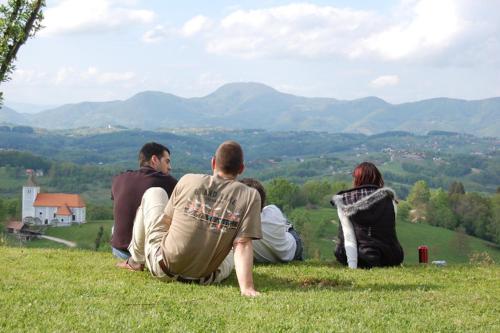 a group of people sitting on top of a hill at Holiday House PANORAMA in Podčetrtek