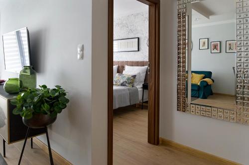 a hallway with a mirror and a room with a bed at Millo Apartament IMPERO z Parkingiem in Poznań