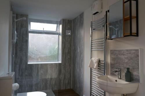 baño con lavabo y ventana en K Suites - Wellington Street 1 en Gloucester