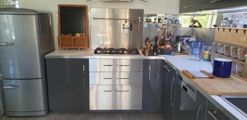 Il comprend une cuisine équipée d'un réfrigérateur en acier inoxydable et d'une cuisinière. dans l'établissement Maison les Sables-d'Olonne bord de mer classé 4 étoiles, à Château-dʼOlonne