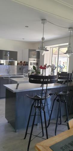 une cuisine avec un comptoir avec deux tabourets dans l'établissement Maison les Sables-d'Olonne bord de mer classé 4 étoiles, à Château-dʼOlonne