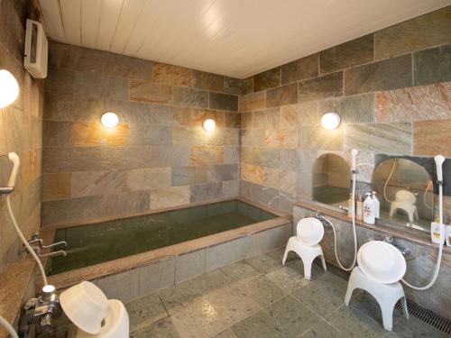 Tabist Hamatoya Ryokan Mens Only في Sodegaura: حمام مع مغسلتين وحوض استحمام