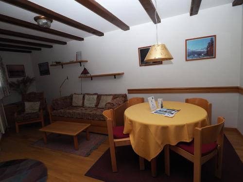 a living room with a table and a couch at Residenz La Mora in La Punt-Chamues-ch