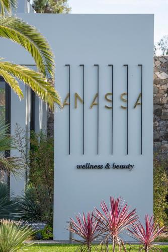 a sign for the entrance to a building with plants at Caravia Beach Hotel in Marmari