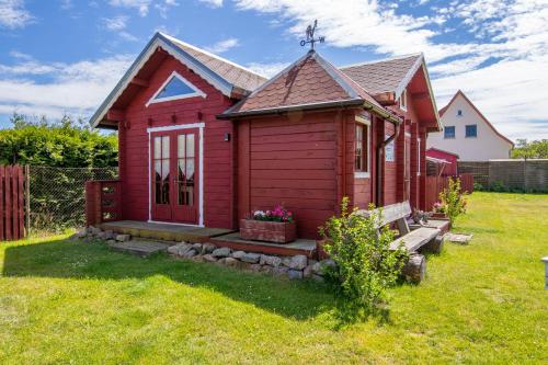 a red tiny house in a yard at Zur Sonne in Freest