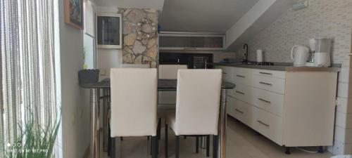a kitchen with white cabinets and white counter tops at Apartment Marina in Brzac
