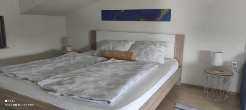 a bedroom with a large bed with white sheets at Apartment Marina in Brzac