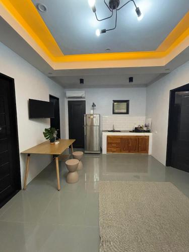 a large kitchen with a yellow ceiling and a table at Jolie Joes One Bedroom Unit in Tagudin