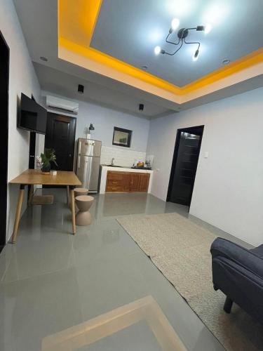 a living room with a table and a kitchen at Jolie Joes One Bedroom Unit in Tagudin