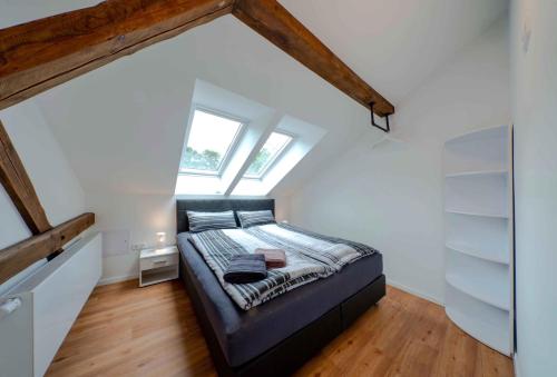 ein Schlafzimmer mit einem schwarzen Bett im Dachgeschoss in der Unterkunft Ferienwohnung auf Zürns Hoff in Bötersen