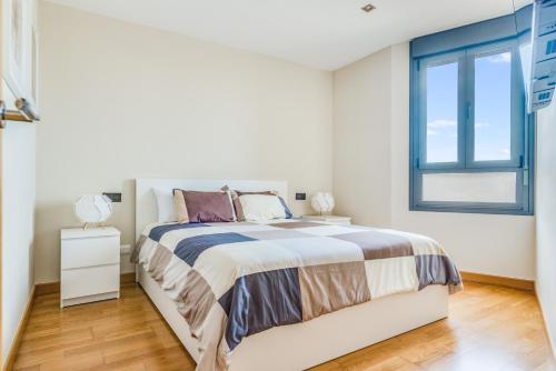 een witte slaapkamer met een bed en een raam bij Home2Book Charming Urban Siete Palmas in Las Palmas de Gran Canaria