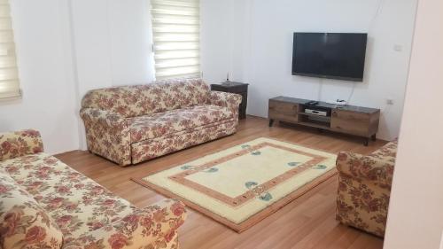 a living room with a couch and a tv at Huge Evleri 2 in Marmaris