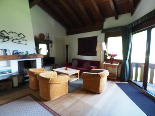 a living room with a couch and a table and chairs at Residenz La Mora in La Punt-Chamues-ch