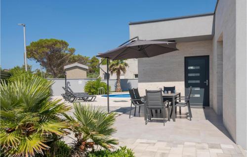 a patio with a table and chairs and an umbrella at Awesome Home In Vir With Sauna in Vir
