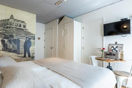 a bedroom with a bed and a tv on a wall at Hotel Pannenkoekhuis Vierwegen in Domburg