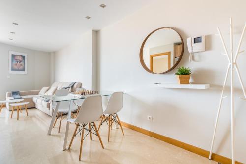 a living room with a table and a mirror at Home2Book Charming Urban Siete Palmas in Las Palmas de Gran Canaria