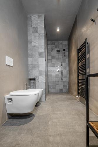a bathroom with a large white tub and a shower at Curt di Clement Eco Mobility Hotel in Tirano