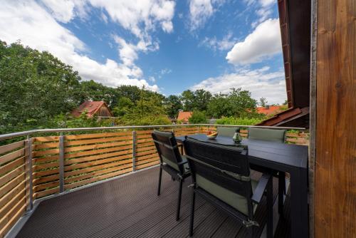 a balcony with a table and chairs on a deck at Ferienwohnung auf Zürns Hoff in Bötersen