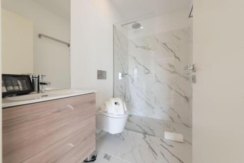 La salle de bains est pourvue d'une douche, de toilettes et d'un lavabo. dans l'établissement BmyGuest - Sao Vitor Balcony Apartment, à Porto