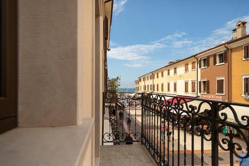 a balcony of a building with a view of a street at BAUR SUITE - Regarda Travel in Bardolino