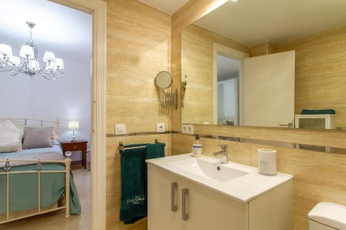 La salle de bains est pourvue d'un lavabo et d'un miroir. dans l'établissement Large Bright Henrys Holiday Apartment on Spains Costa Calida, à Águilas