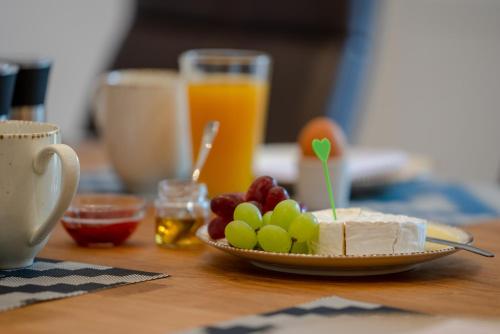a plate of cheese and fruit on a table at Ferienwohnung auf Zürns Hoff in Bötersen