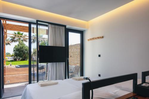 a bedroom with a bed and a large window at La Mer Resort Spa Crete in Georgioupolis